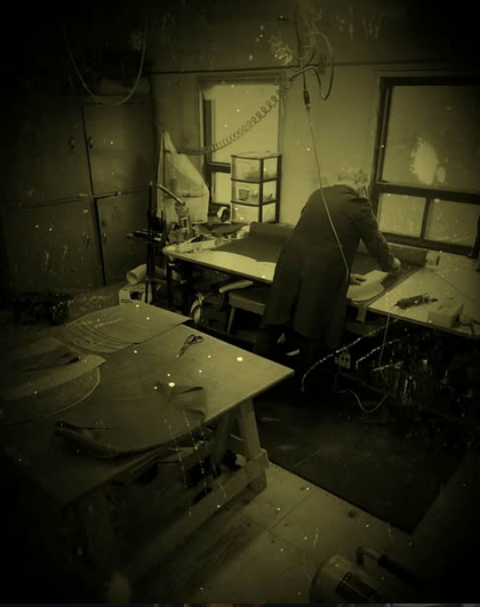 Henderson Furniture Repair craftsman repairing an antique sofa in the workshop.